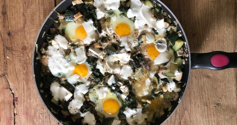 Groene shakshuka eieren gestoofd in groente